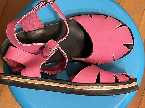 Pink leather fisherman-style sandals with a quarter strap and black rubber soles